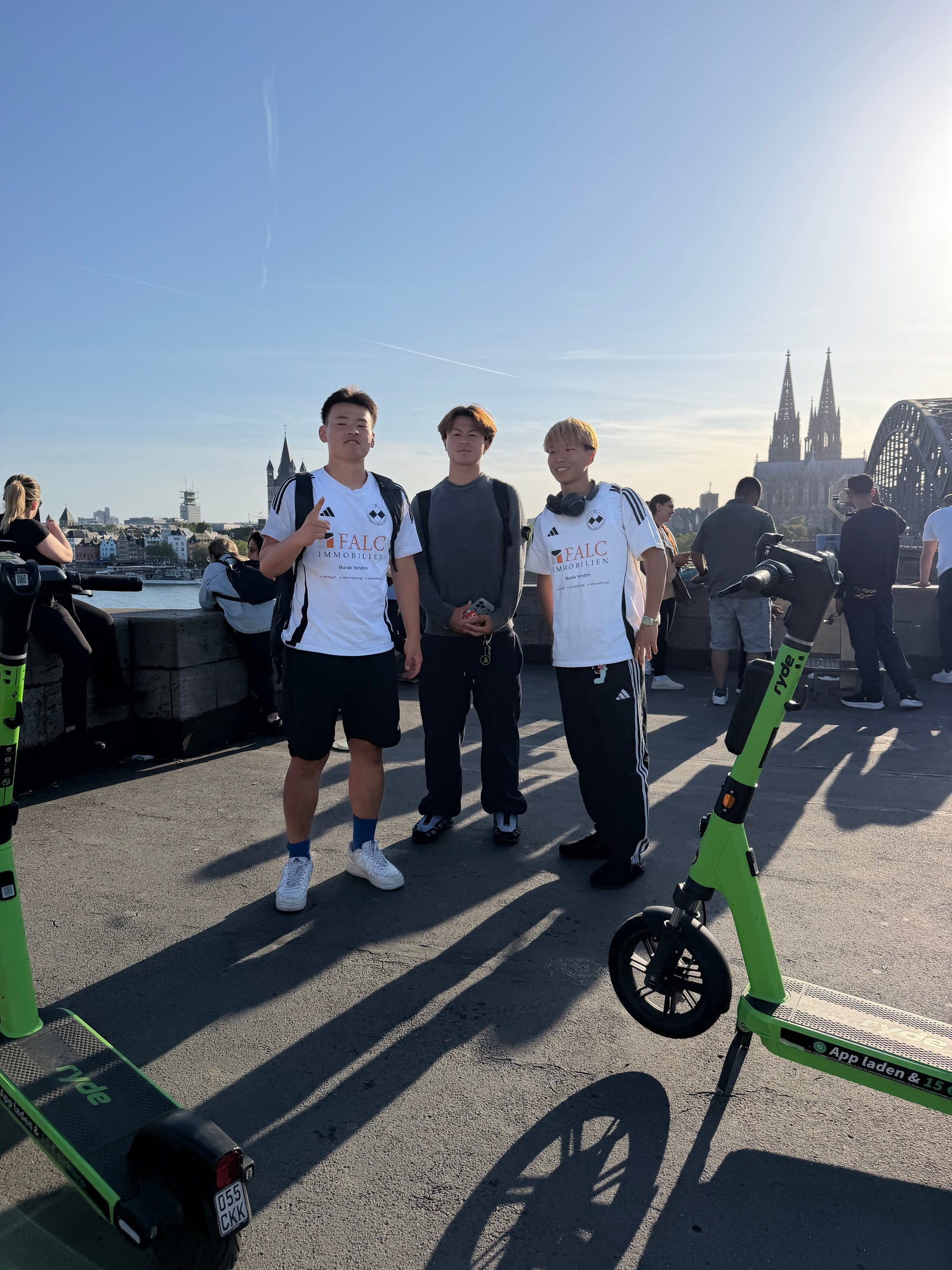 ケルン大聖堂前で電動スクーターに乗る留学生たち
